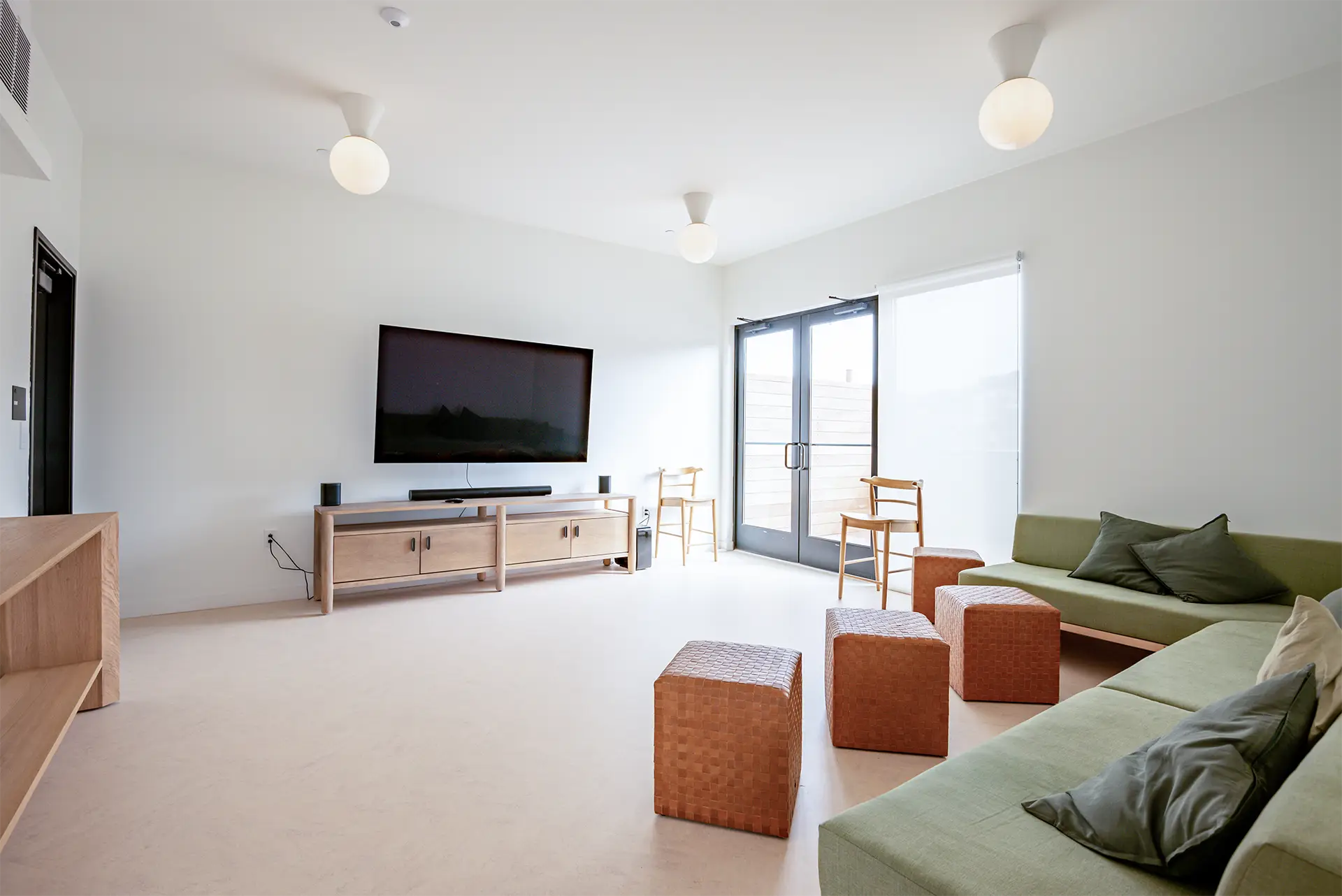 Interior view of a furnished living and seating area with light-colored floors and walls.